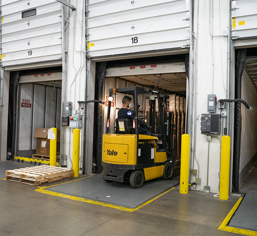 Person on forklift moving pallets out of a truck,