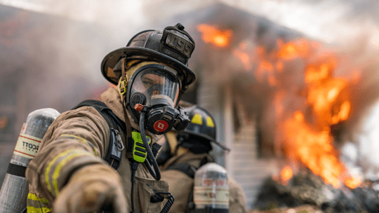 pompiere con radio davanti a un edificio in fiamme