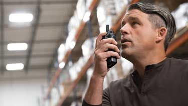 Man talking into a radio in a distribution center