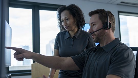 Employees pointing at computer screen together