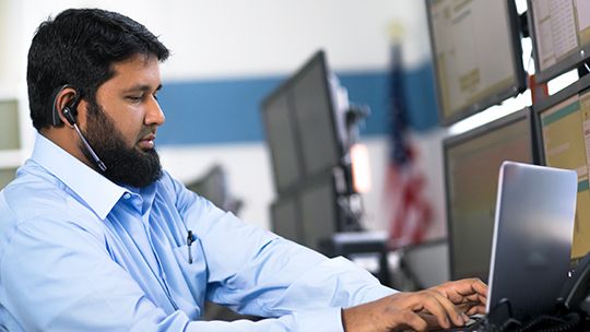man working at laptop with headset