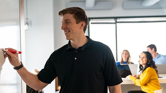 Man writing on whiteboard with marker