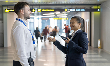Two Belgrade Airport employees in conversation, one has a radio