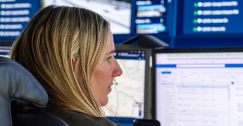 Woman looking at multiple monitors