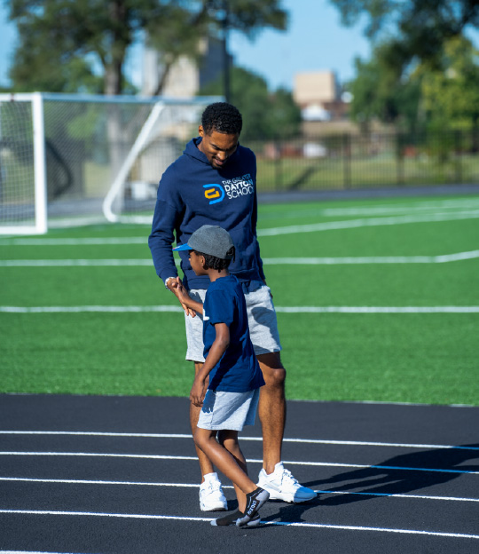 A teacher at Greater Dayton Schools clasps a student’s hand
