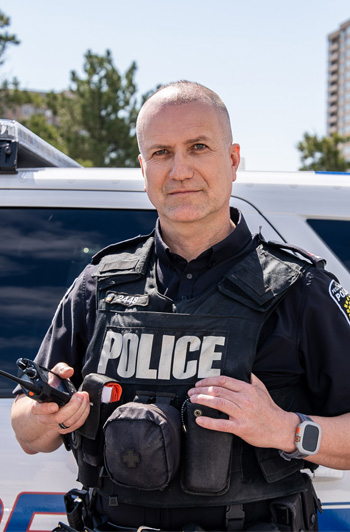 Peel Regional Police officer in front of police car