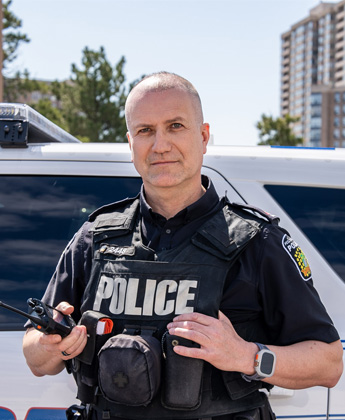 Peel Regional Police officer in front of police car