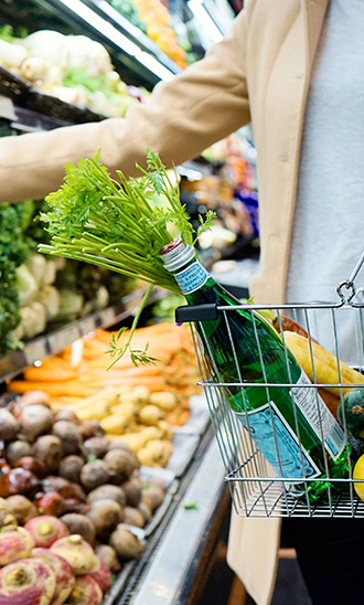 A shopper with a basket of groceries at a supermarket