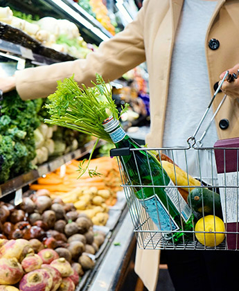 A shopper with a basket of groceries at a supermarket