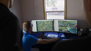 Personnel looking at computer screen of video footage