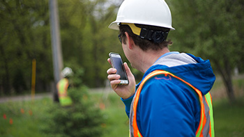 Utility worker using a two-way radio