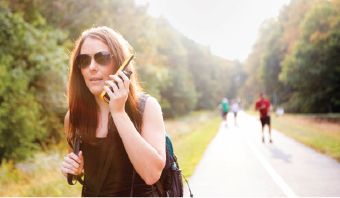 Woman hiking with yellow walkie talkie