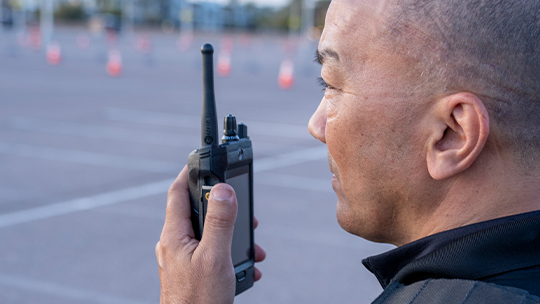 A person speaking into a two-way radio.