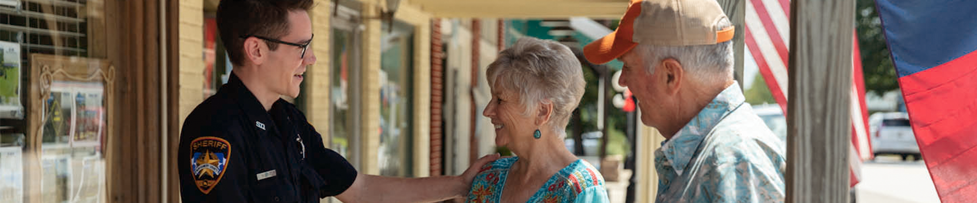 Two people talking to a person in a sheriff's uniform.