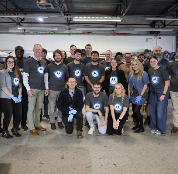 A group of people standing together wearing Motorola Solutions shirts.