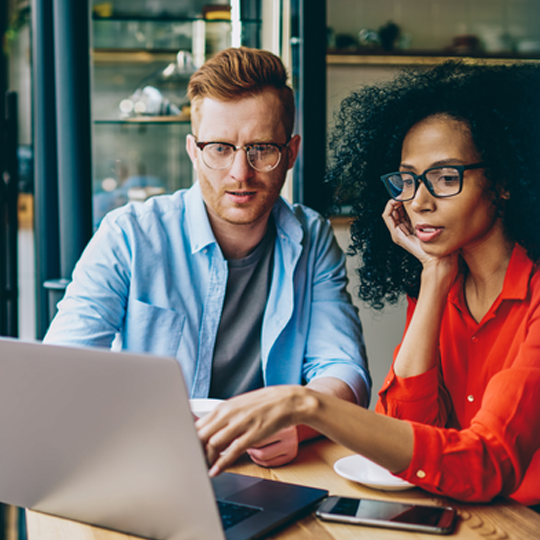 A man and a woman looking at a laptop