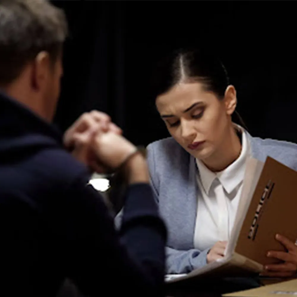 An officer interviewing a witness at a table.
