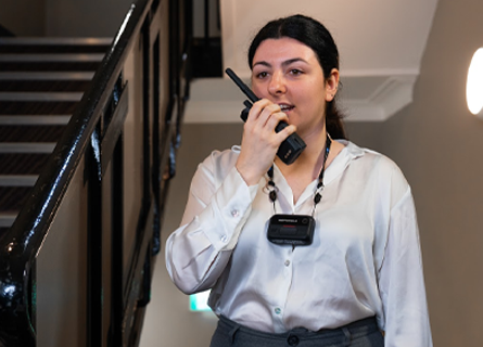 Hotel employee talking in to radio with body camera on