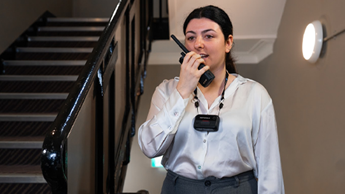 Hotel employee talking in to radio with body camera on