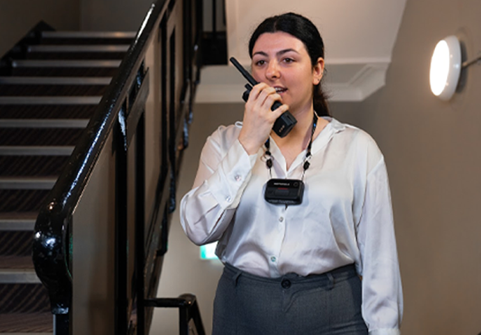 Hotel employee talking in to radio with body camera on