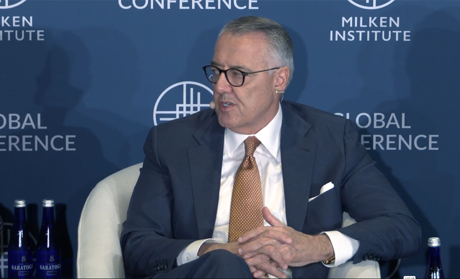 Image of MSI CEO, Greg Brown, sitting in a chair speaking on a Milken Institute Panel