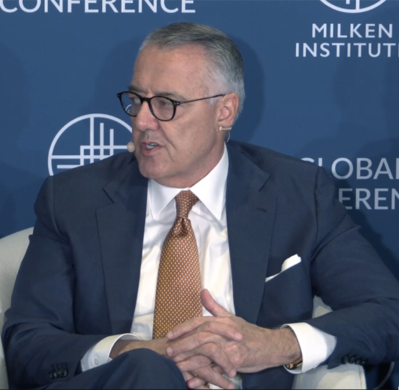 Image of MSI CEO, Greg Brown, sitting in a chair speaking on a Milken Institute Panel