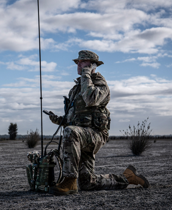 man in military uniform using manpack HF radio