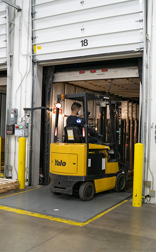 Person on forklift moving pallets out of a truck,