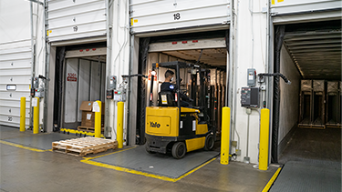 Person on forklift moving pallets out of a truck,