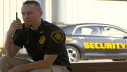 MOTOTRBO Digital Mobile Radios Security guard talking on radio with patrol car in background