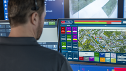 Teldio TruFleet Dispatcher wearing headset and looking at Avtec Scout screen with Teldio map