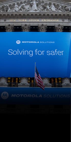 Image of front of New York Stock Exchange with Motorola Solutions Solving for Safer Banner