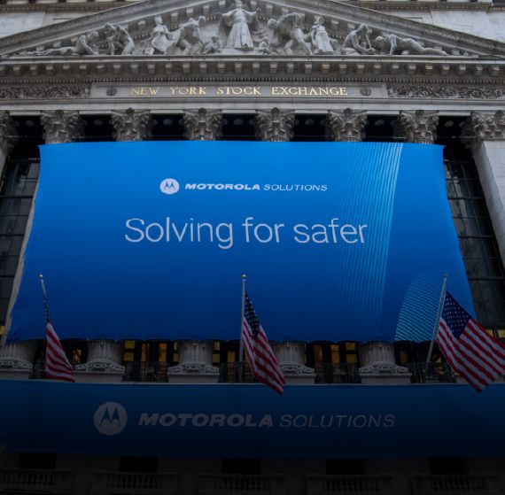 Image of front of New York Stock Exchange with Motorola Solutions Solving for Safer Banner