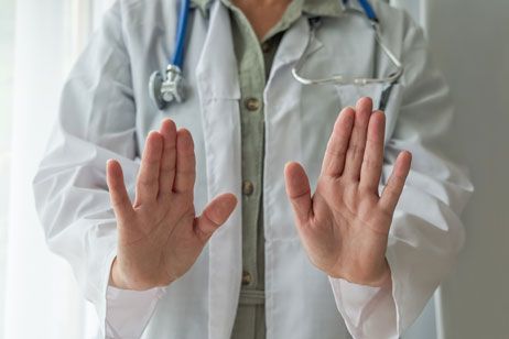 Image of doctor with their hands up