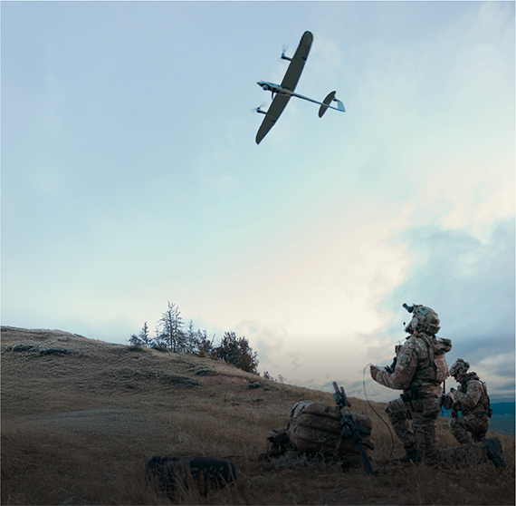 Image of members of the military in camouflage outfit operating a drone in an open field